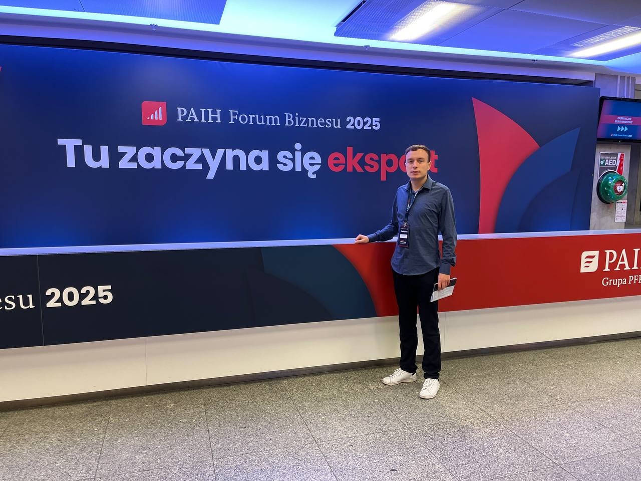 The author of eastok in front of the PAIH Business Forum 2025 signage