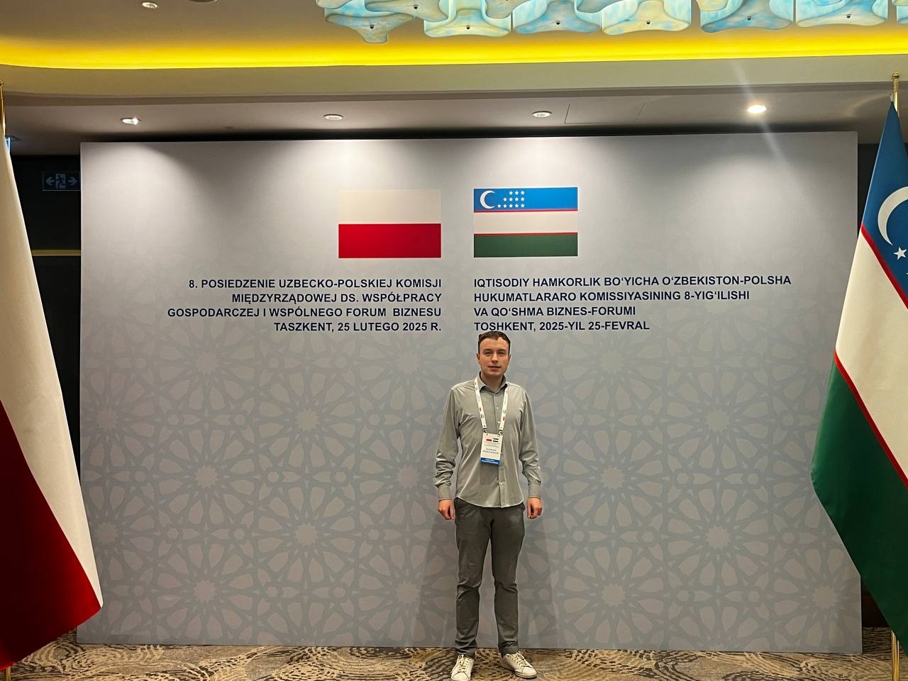 The author of eastok in front of the Poland–Uzbekistan Business Forum 2025 signage in Tashkent.
