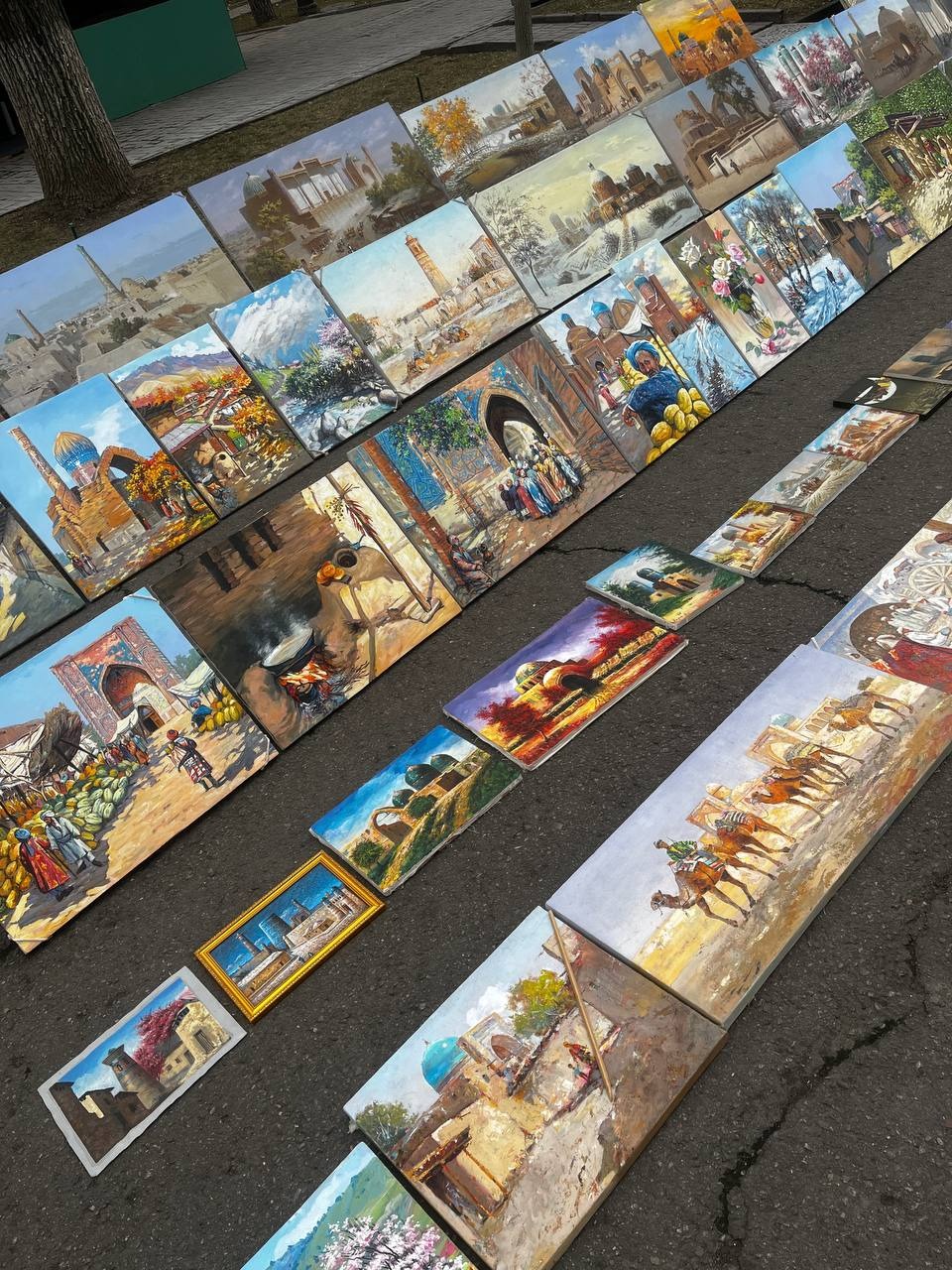 Obrazy przedstawiające dawny Uzbekistan, historyczne budowle, wielbłądy i sceny z życia mieszkańców.