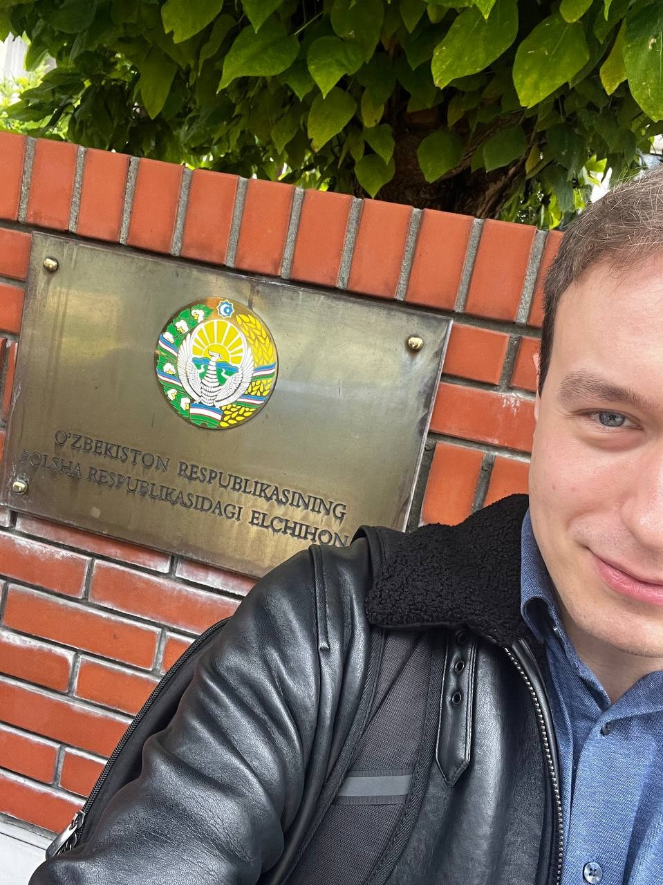 Autor eastok przed Ambasadą Republiki Uzbekistanu w Warszawie, na tle tablicy z nazwą placówki.